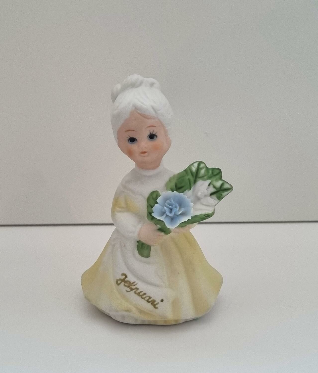 Figurin, dam som håller i en blombukett