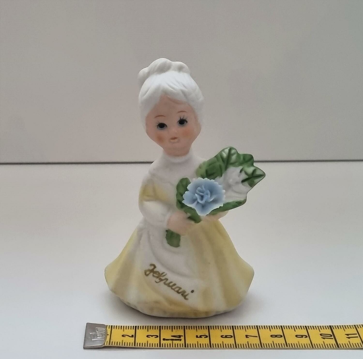 Figurin, dam som håller i en blombukett