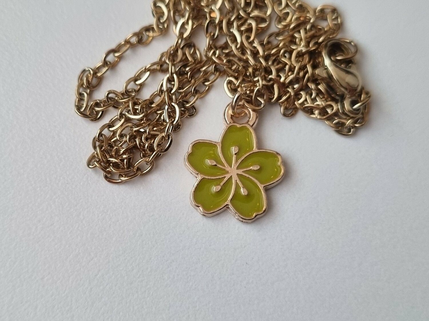 Halsband med en limegrön blomma