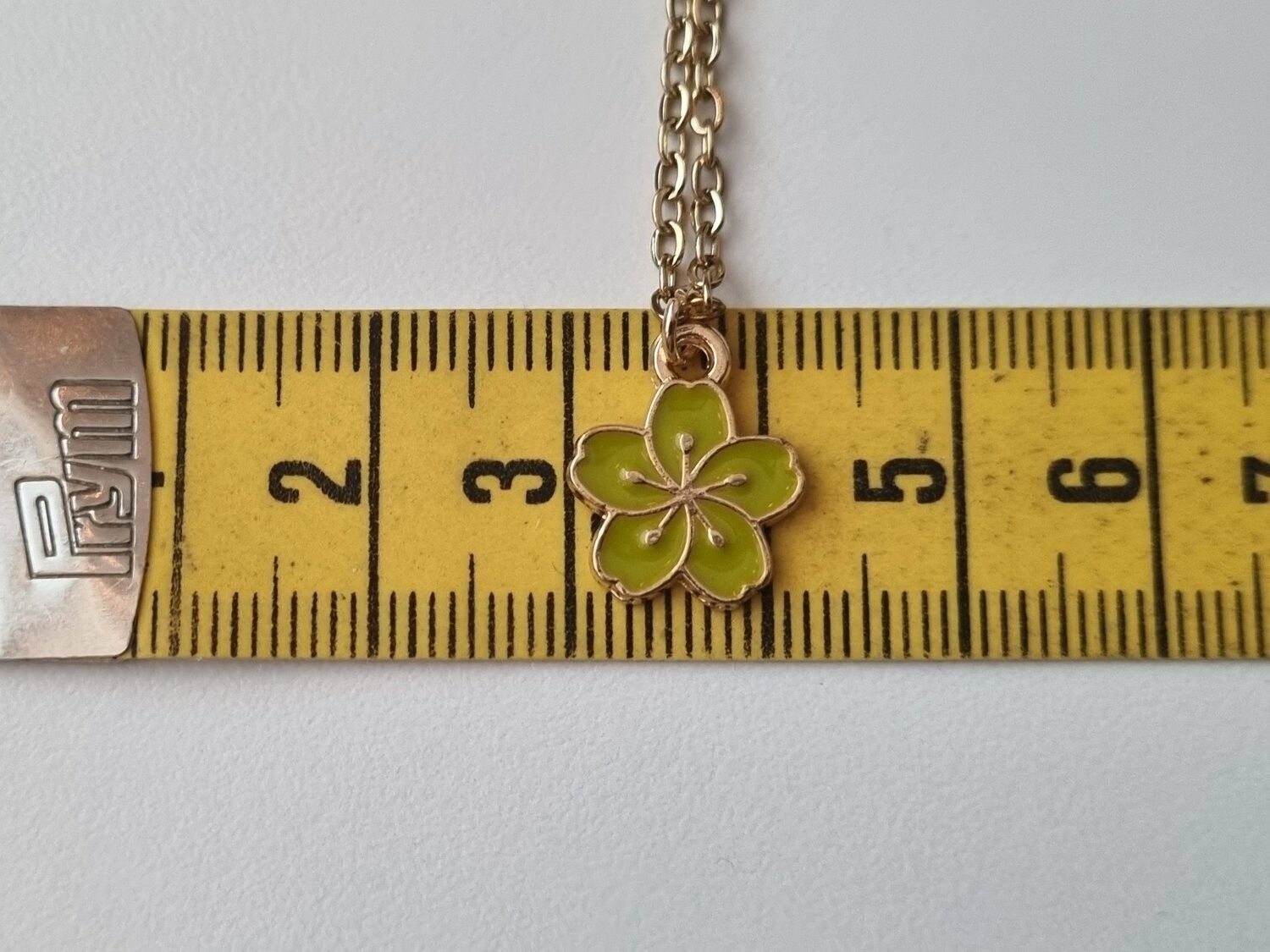 Halsband med en limegrön blomma