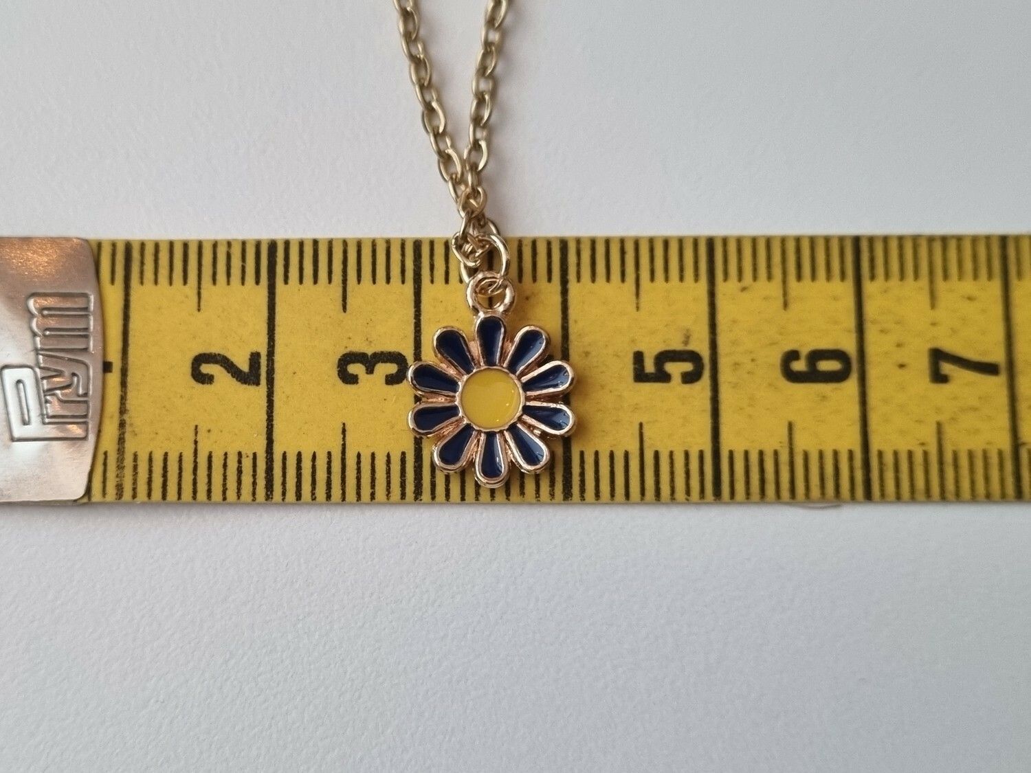 Halsband med en blå blomma och gul knopp