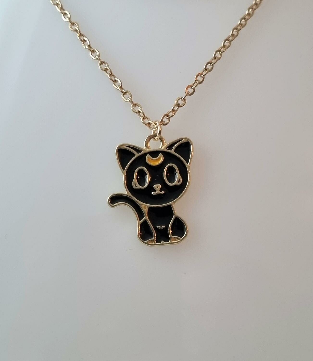Guldfärgat halsband (60 cm) med en söt liten svart katt som berlock