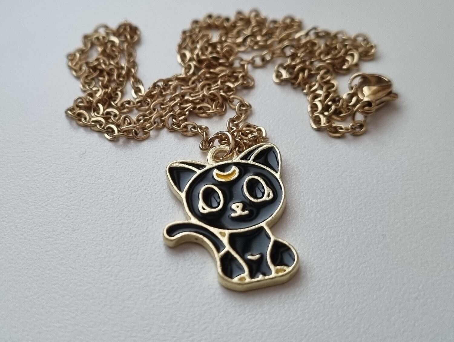 Guldfärgat halsband (60 cm) med en söt liten svart katt som berlock