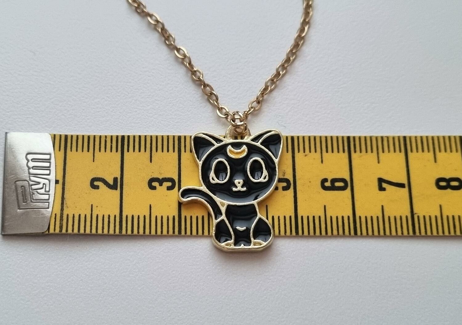 Guldfärgat halsband (60 cm) med en söt liten svart katt som berlock