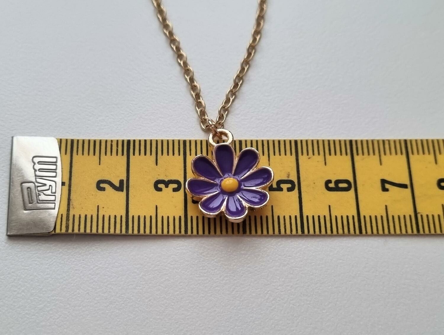 Guldfärgat halsband (60 cm) med en lila blomma