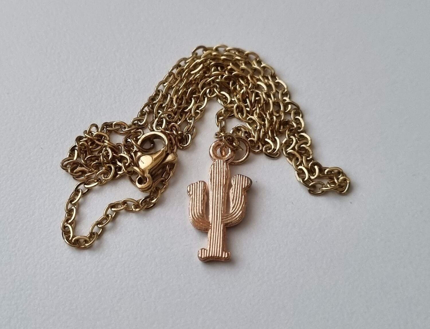 Guldfärgat halsband med en liten kaktus