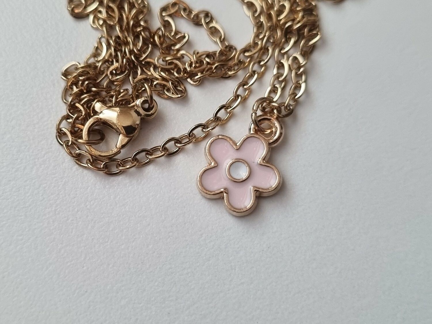 Halsband med en rosa liten blomma
