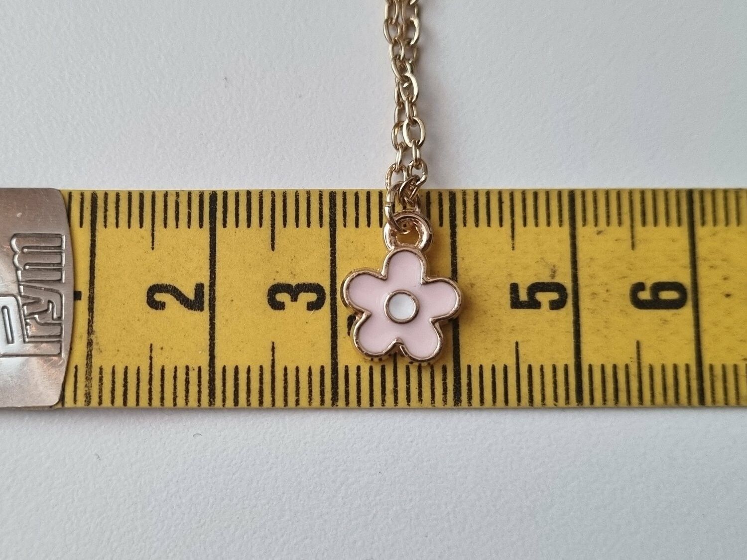 Halsband med en rosa liten blomma