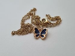 Guldfärgat halsband med en svart fjäril / fjärilsberlock