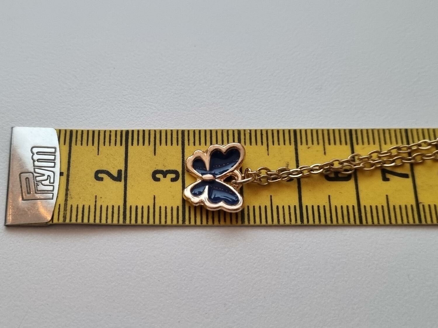 Guldfärgat halsband med en svart fjäril / fjärilsberlock