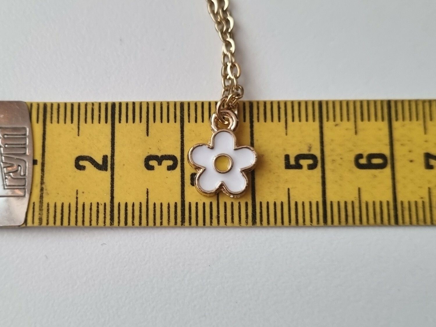 Halsband med en vit liten blomma