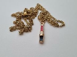 Guldfärgat halsband med ett läppstift / läppstiftsberlock
