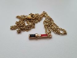 Guldfärgat halsband med ett läppstift / läppstiftsberlock