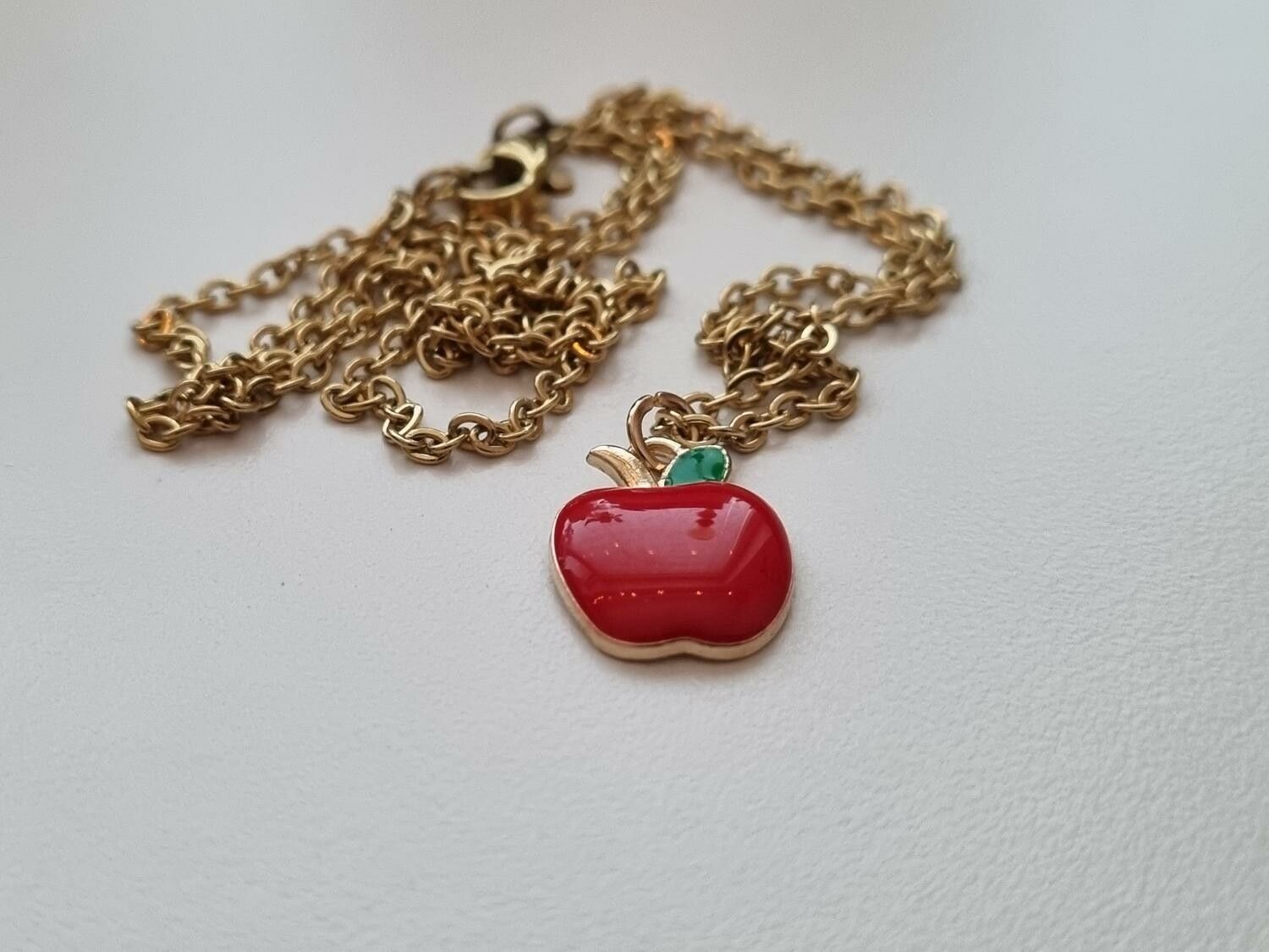 Guldfärgat halsband med ett äpple / äppleberlock