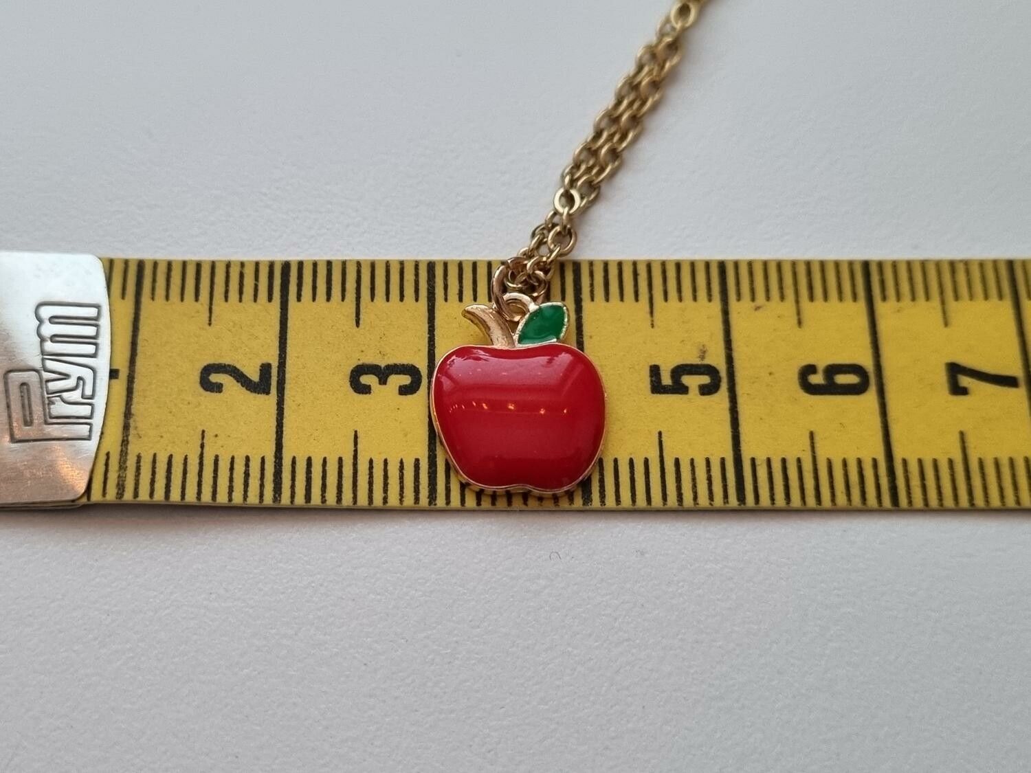 Guldfärgat halsband med ett äpple / äppleberlock