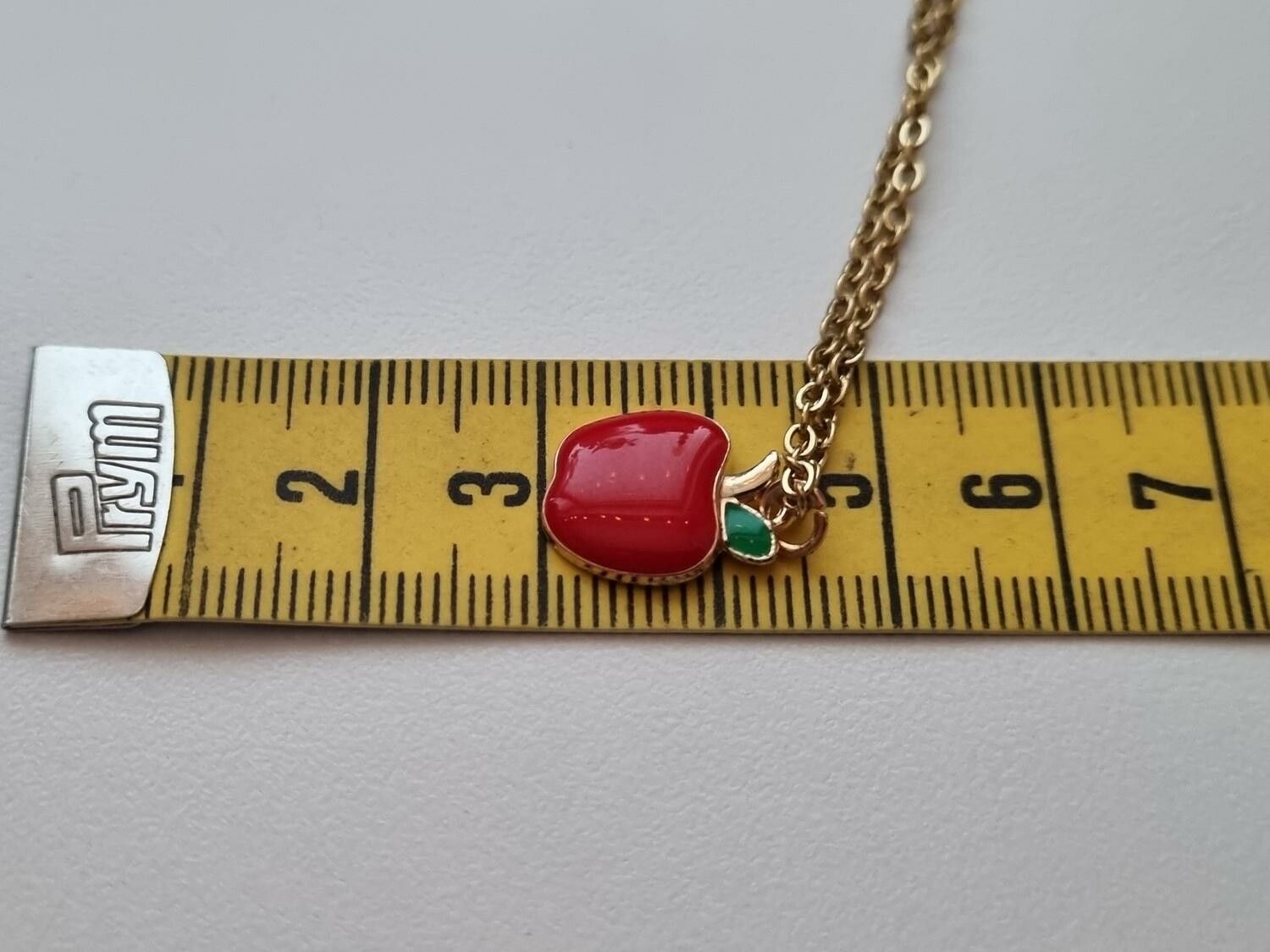 Guldfärgat halsband med ett äpple / äppleberlock
