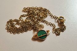 Guldfärgat halsband med en grön planet, berlock / charm