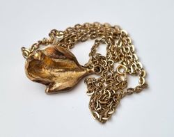 Guldfärgat halsband med ros. Svårtydda stämplar