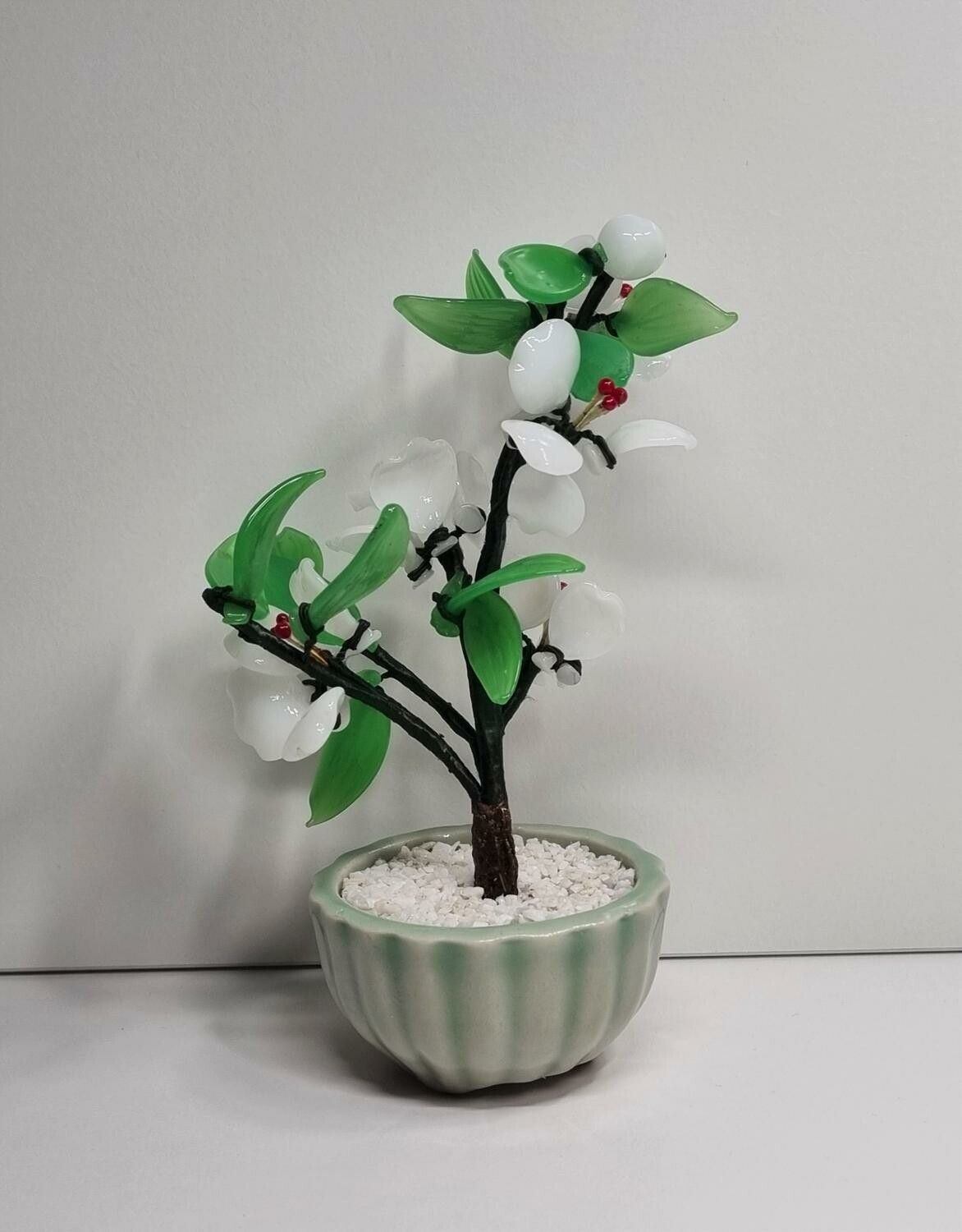Fin liten prydnad, växt / glasblomma med vita och gröna glasblad
