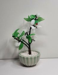 Fin liten prydnad, växt / glasblomma med vita och gröna glasblad