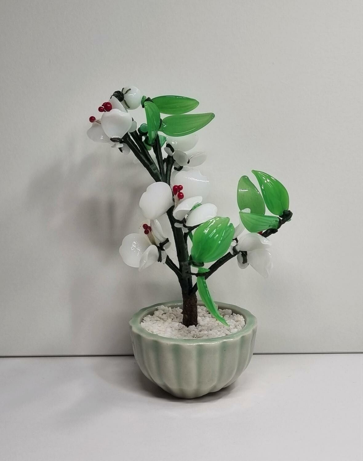 Fin liten prydnad, växt / glasblomma med vita och gröna glasblad