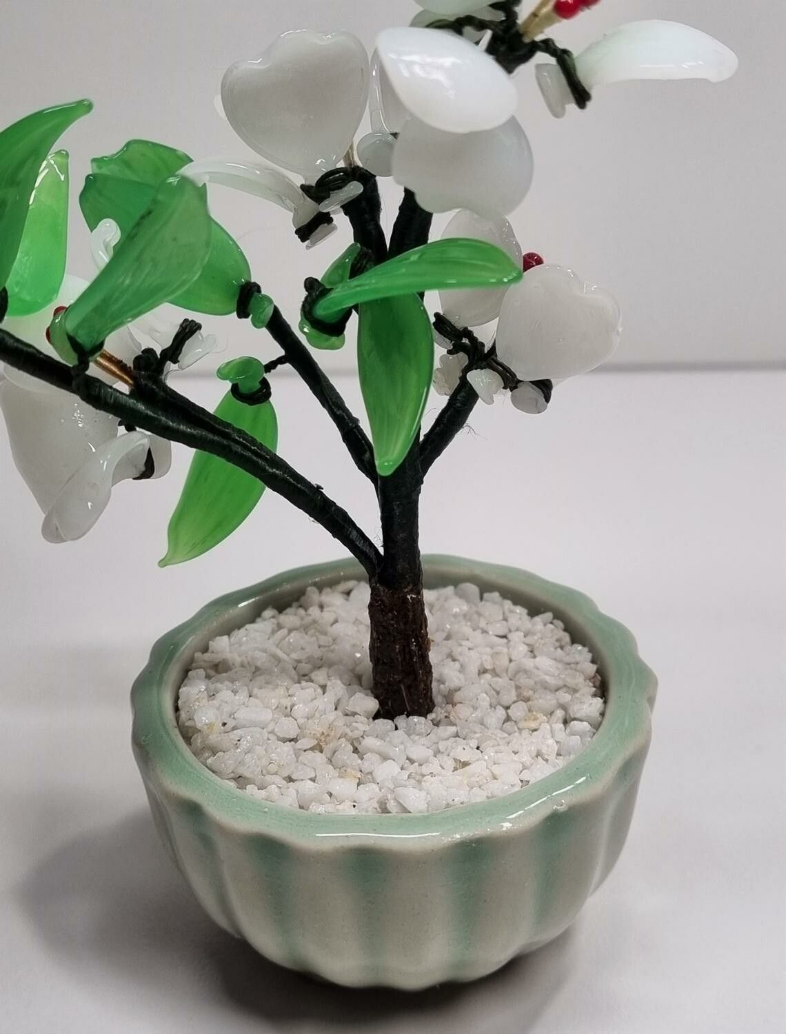 Fin liten prydnad, växt / glasblomma med vita och gröna glasblad