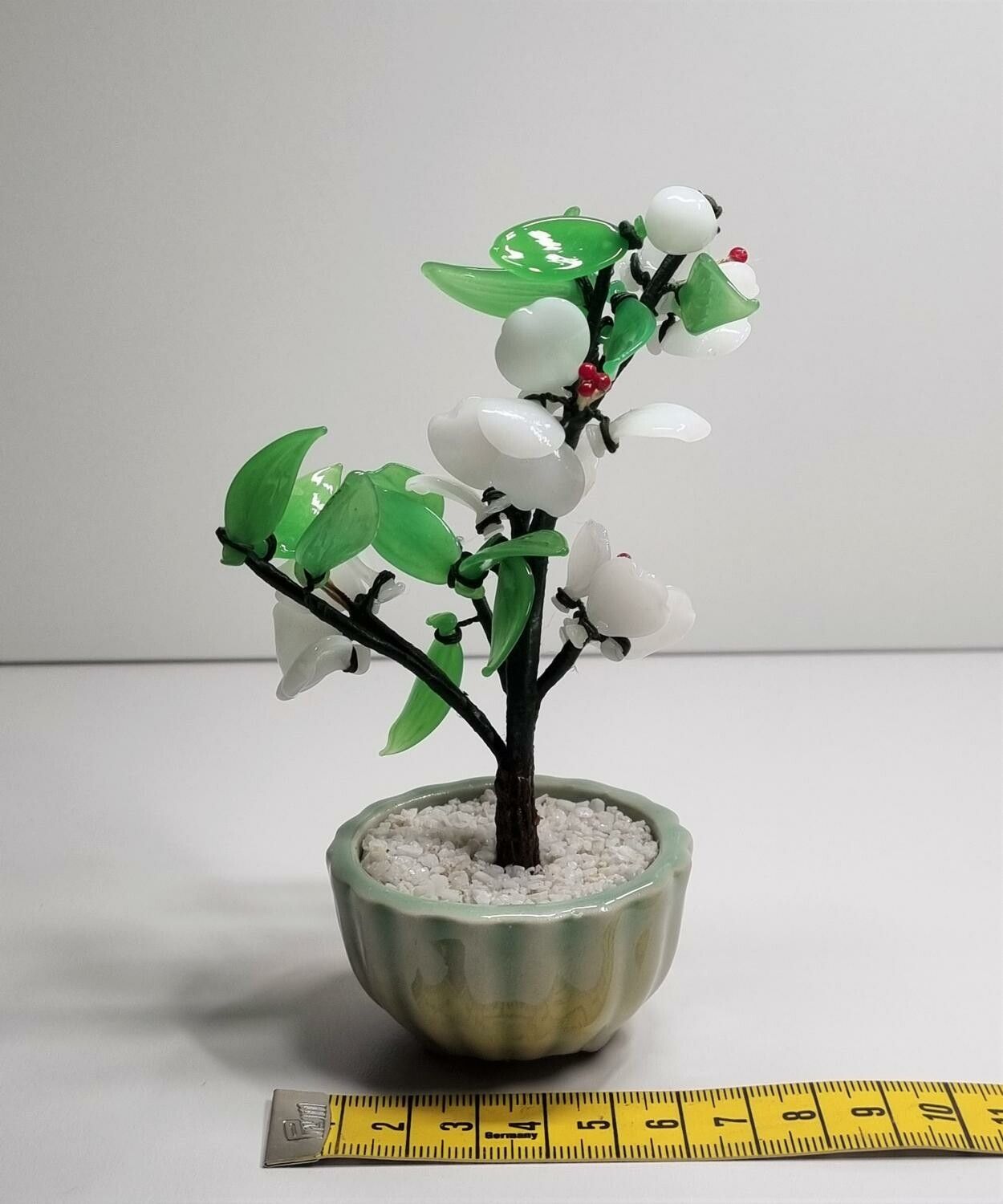 Fin liten prydnad, växt / glasblomma med vita och gröna glasblad