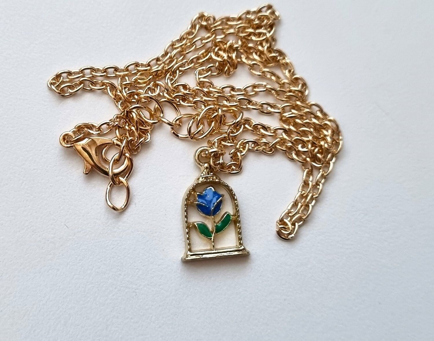 Halsband med blå ros i bur