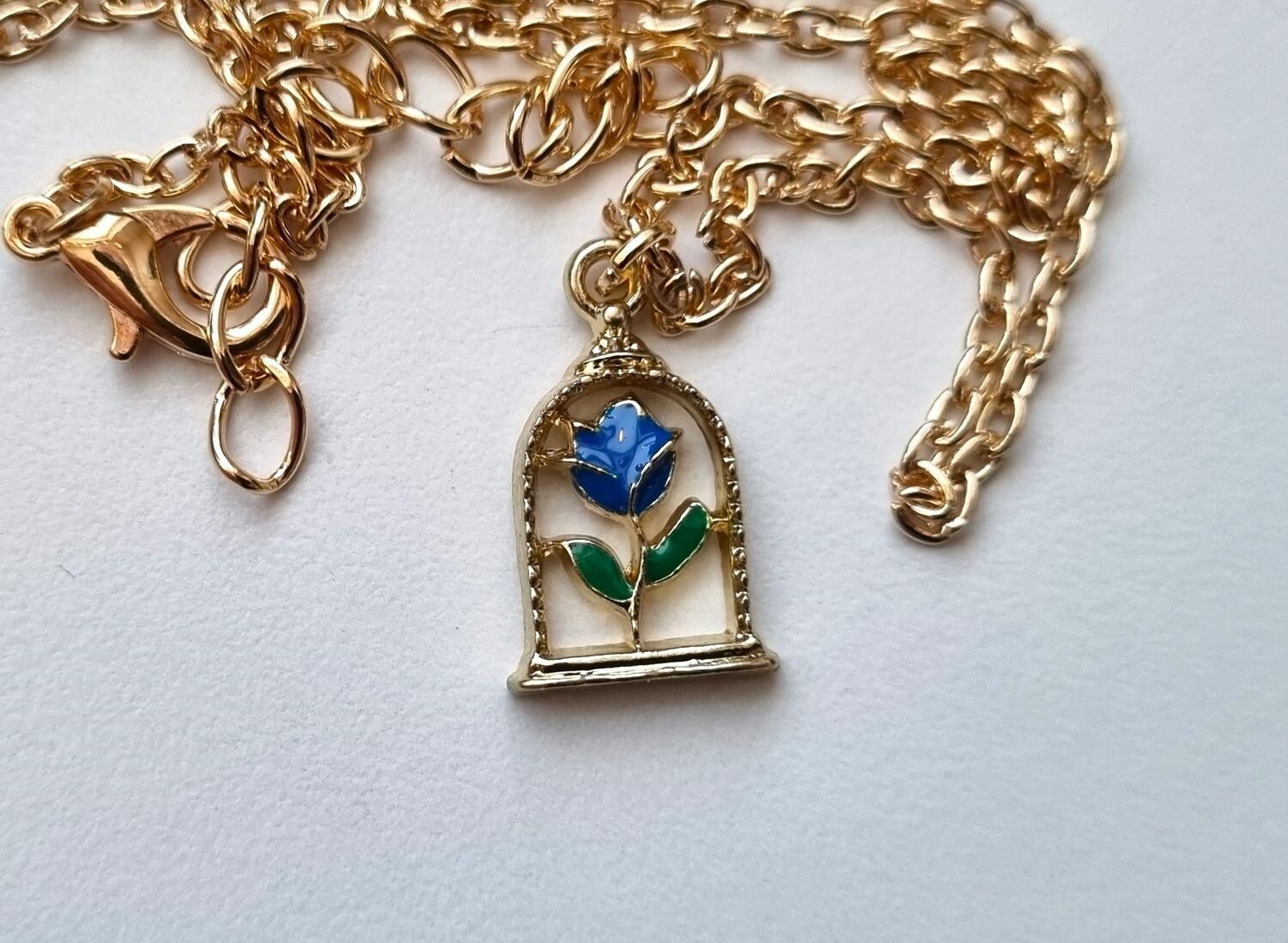 Halsband med blå ros i bur