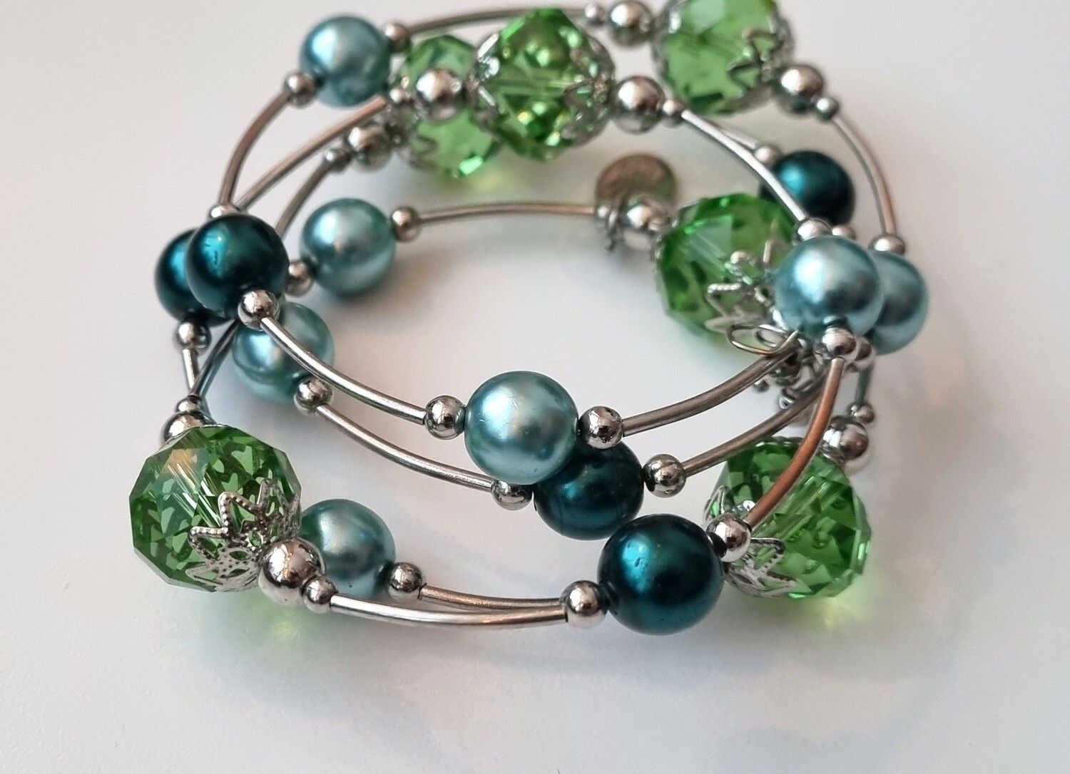 Armband i metall med gröna och turkosa pärlor