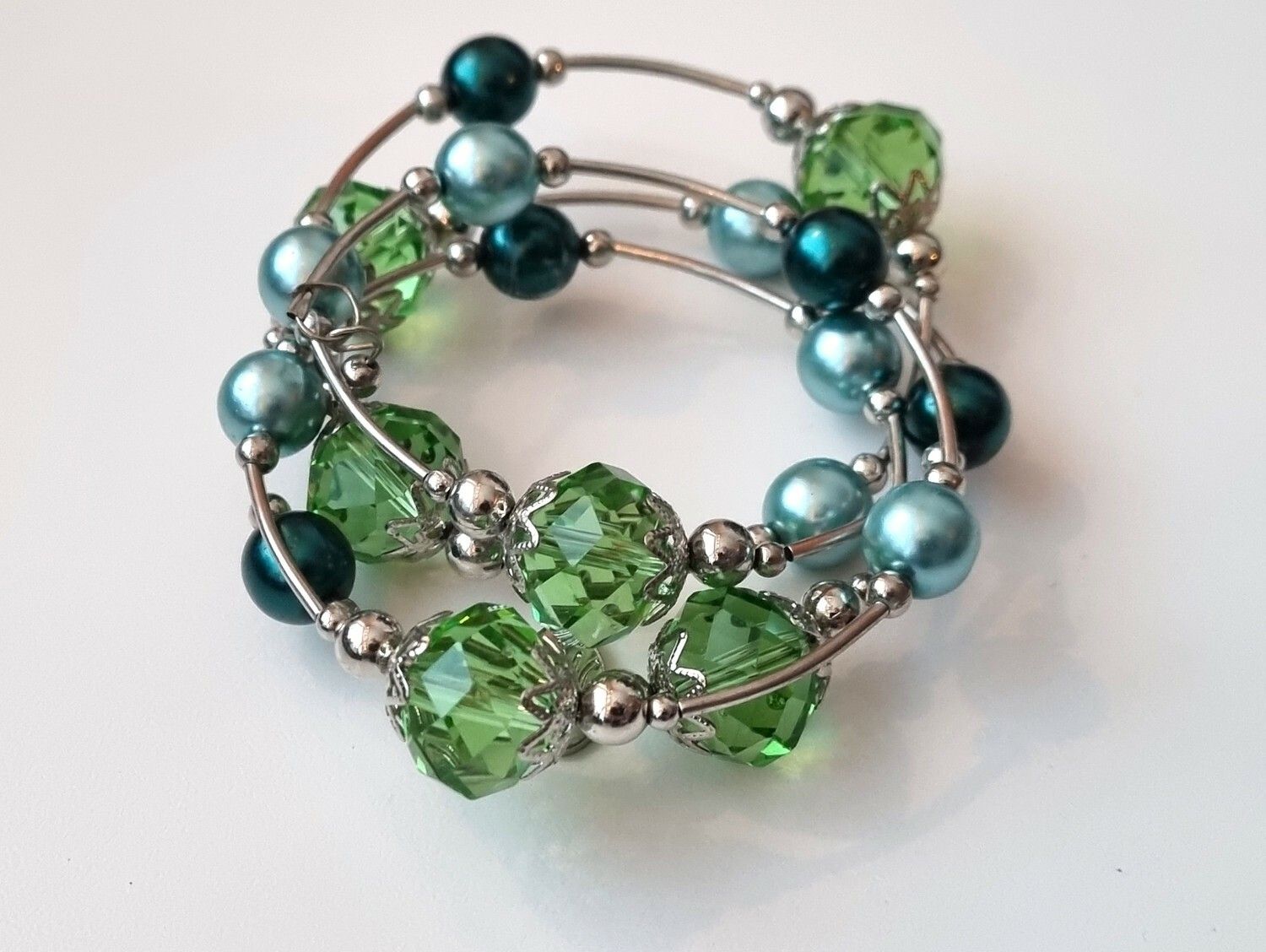 Armband i metall med gröna och turkosa pärlor