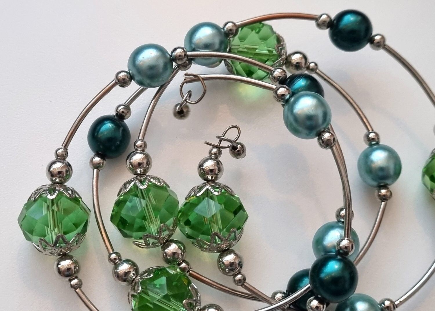 Armband i metall med gröna och turkosa pärlor