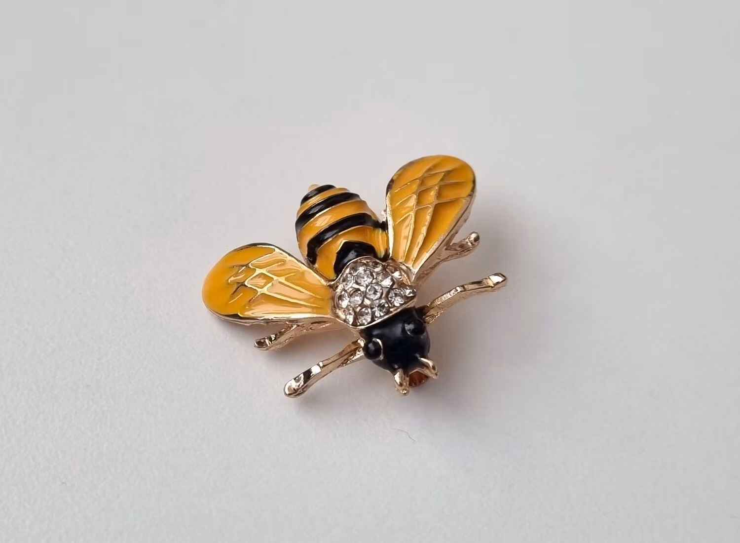 Brosch Geting med vita strasspärlor på ryggen