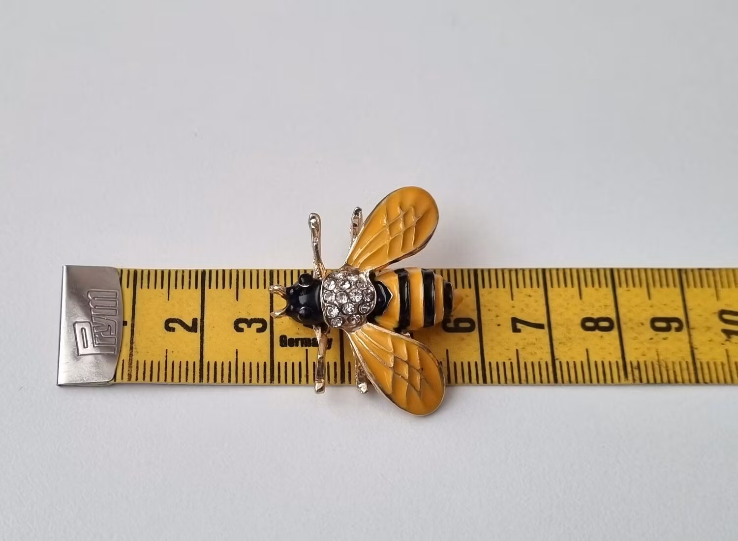 Brosch Geting med vita strasspärlor på ryggen