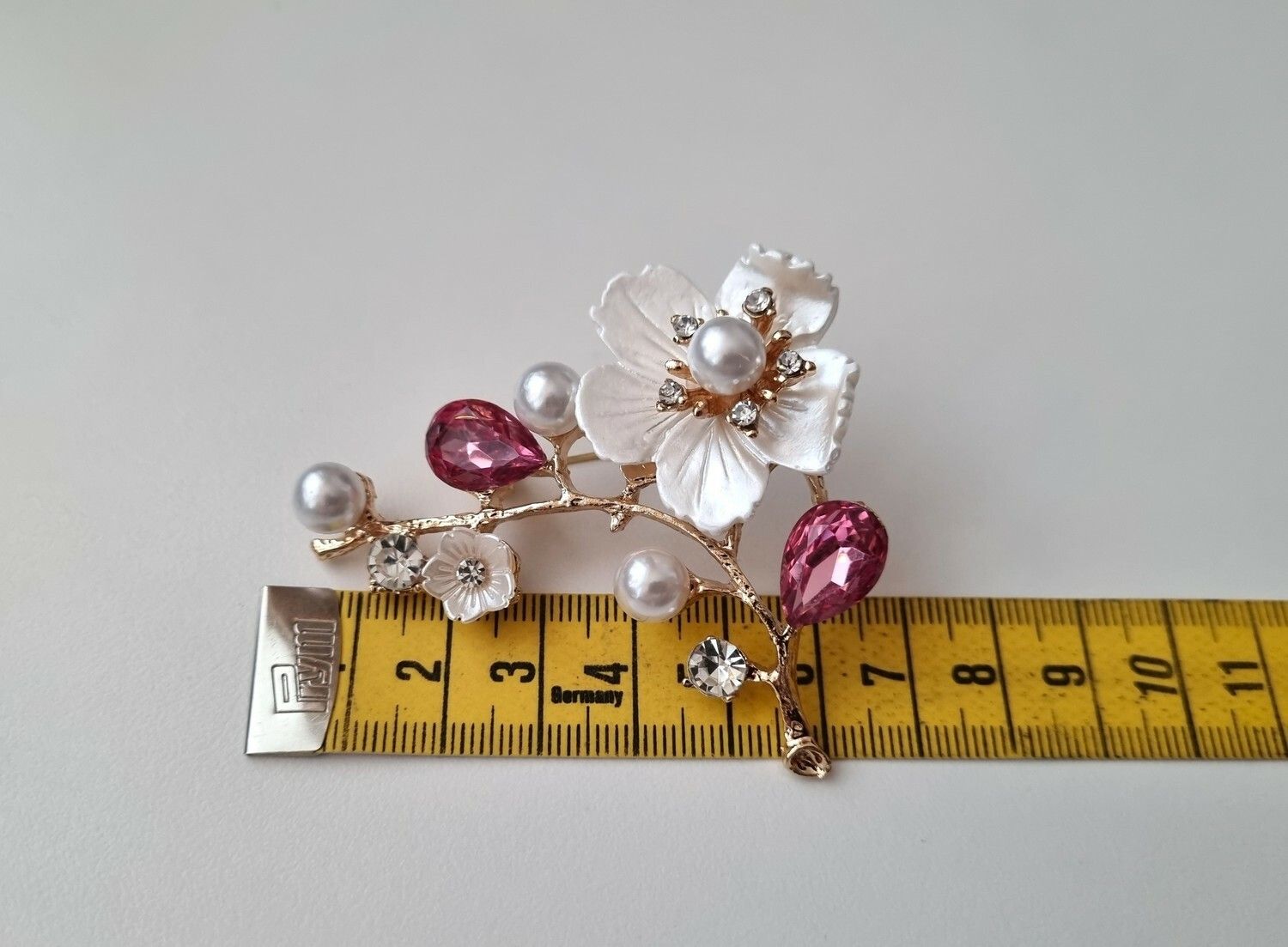 Vacker brosch Blomma med cerisefärgade blad