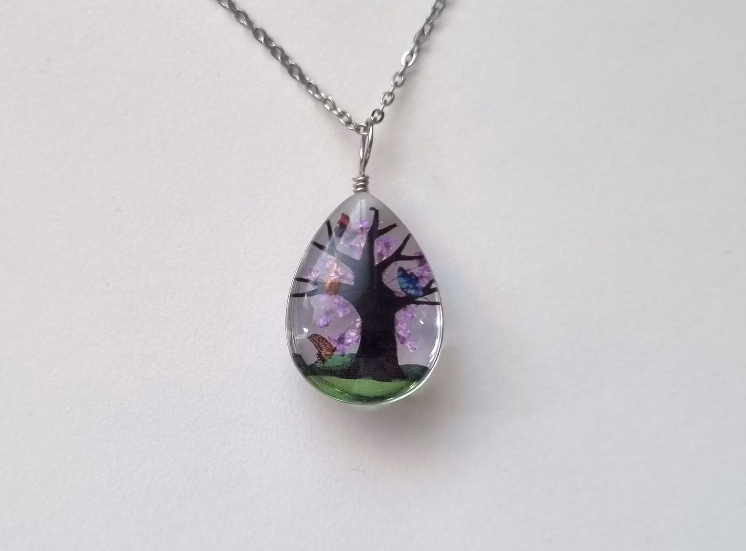 Halsband oval glasberlock med ett målat träd inuti, lila