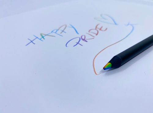 Svart penna som skriver i regnbågsfärger