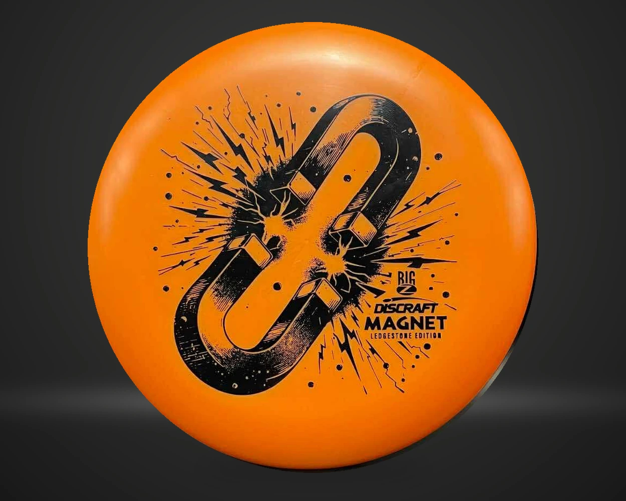 Big Z Magnet Ledgestone 2025 putter i oransje, vist forfra på mørk produktbakgrunn