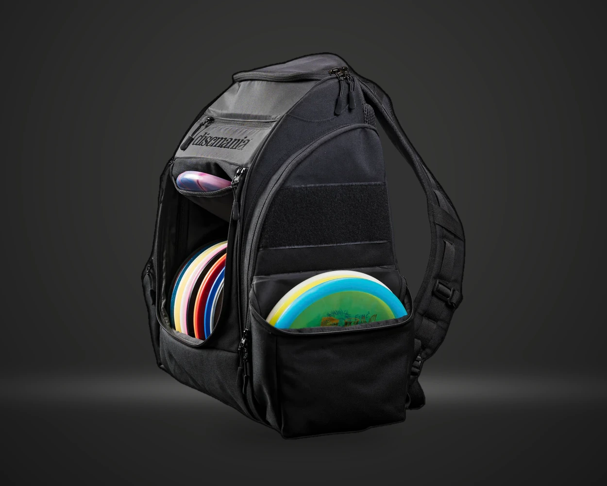 Discmania Tour Bag discgolfsekk i svart, vist fra siden med disc i lomme på mørk produktbakgrunn
