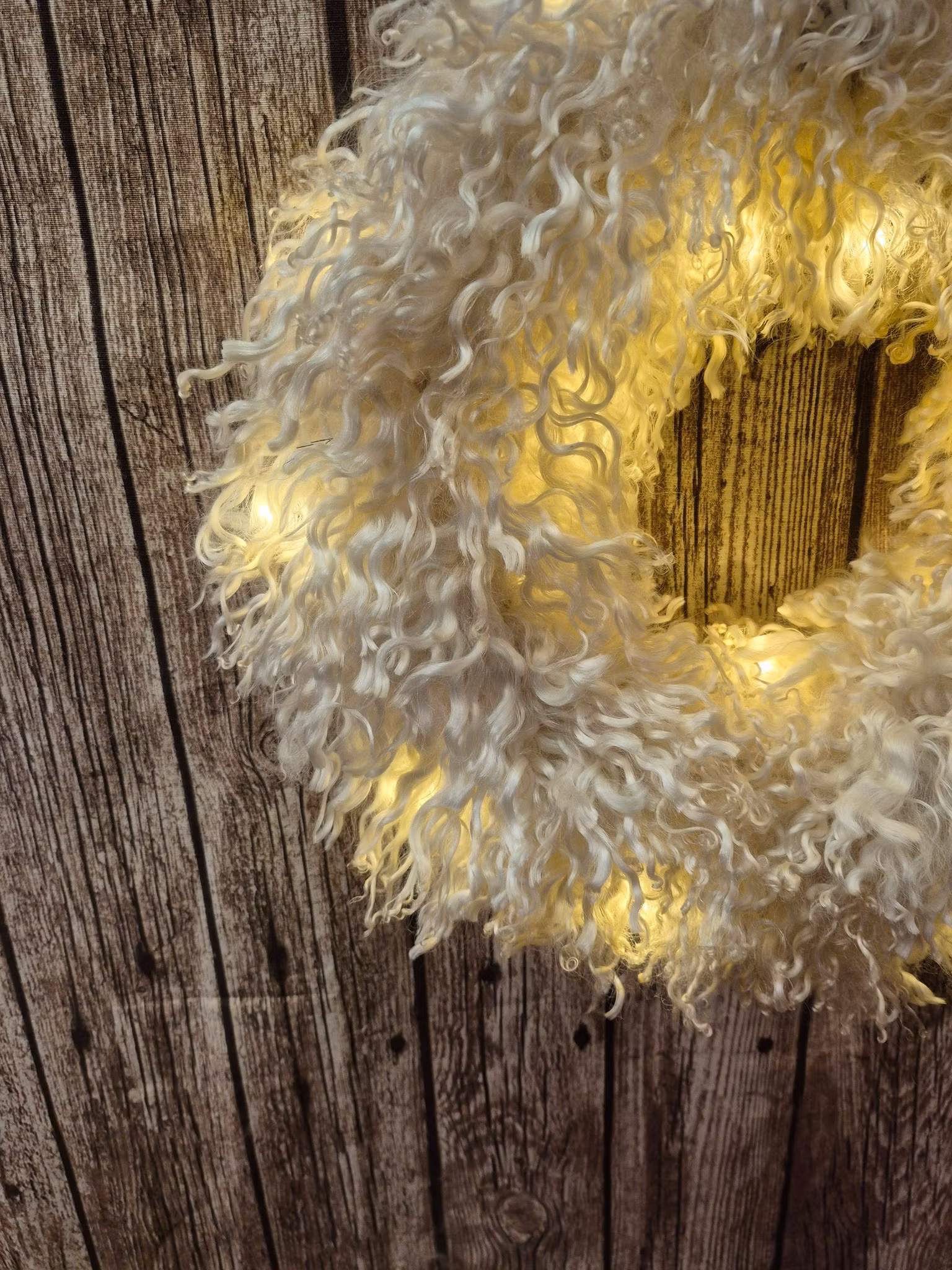 Liten krans med små lockar och belysning. Vit