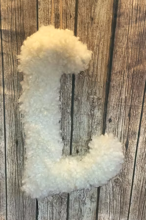 L-bokstavslampa av fårskinn med led-belysning.