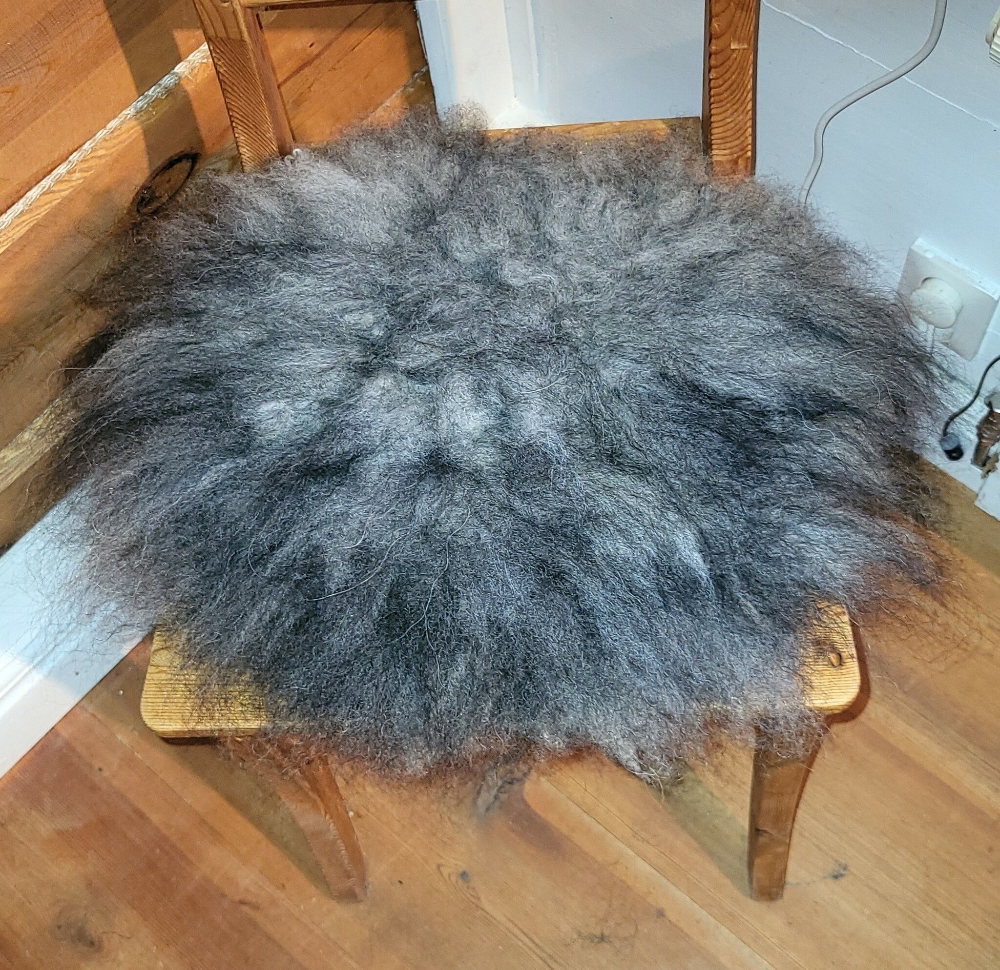 Stolsdyna av fårskinn, svart/grå.
