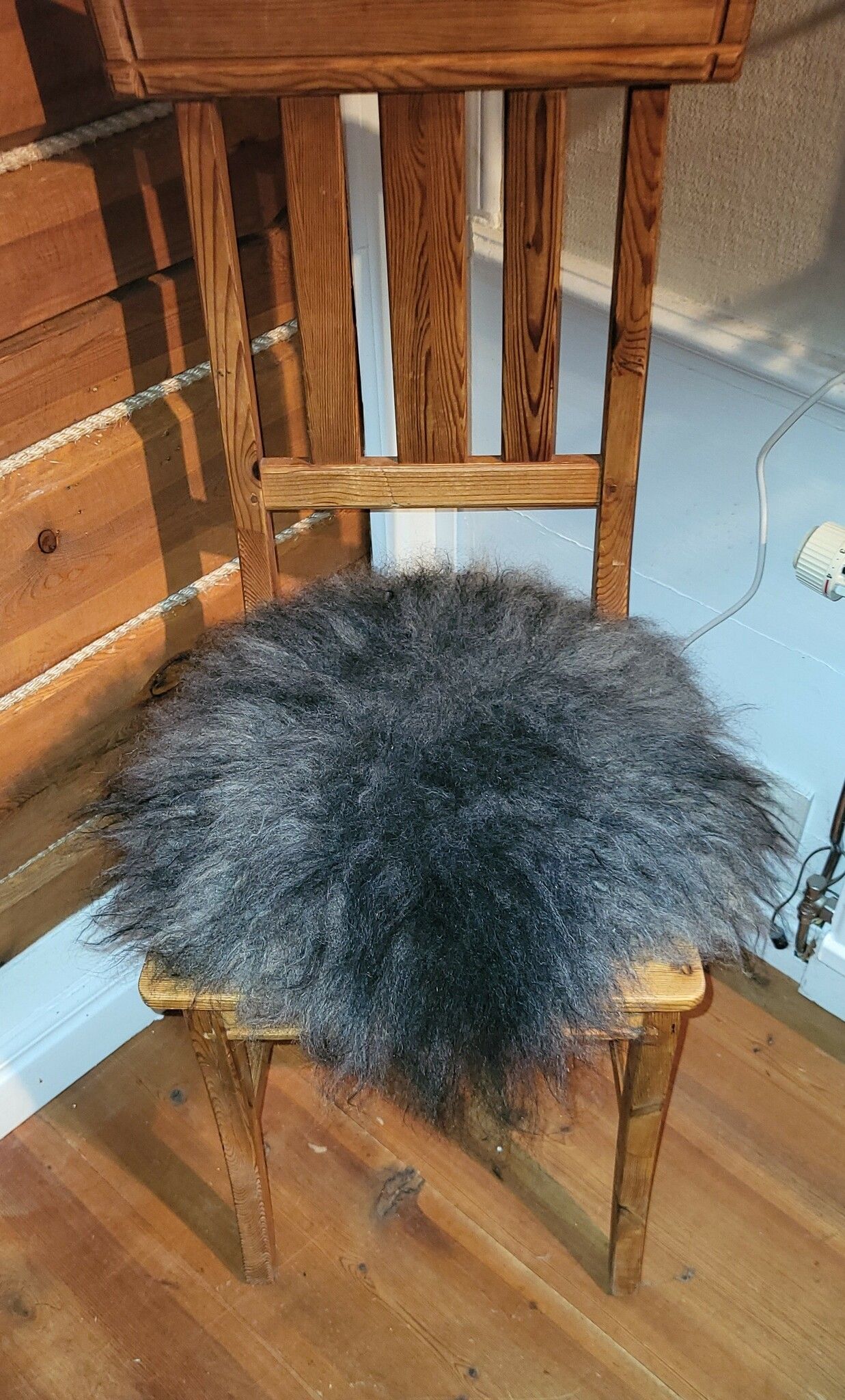 Stolsdyna av fårskinn, svart/grå.