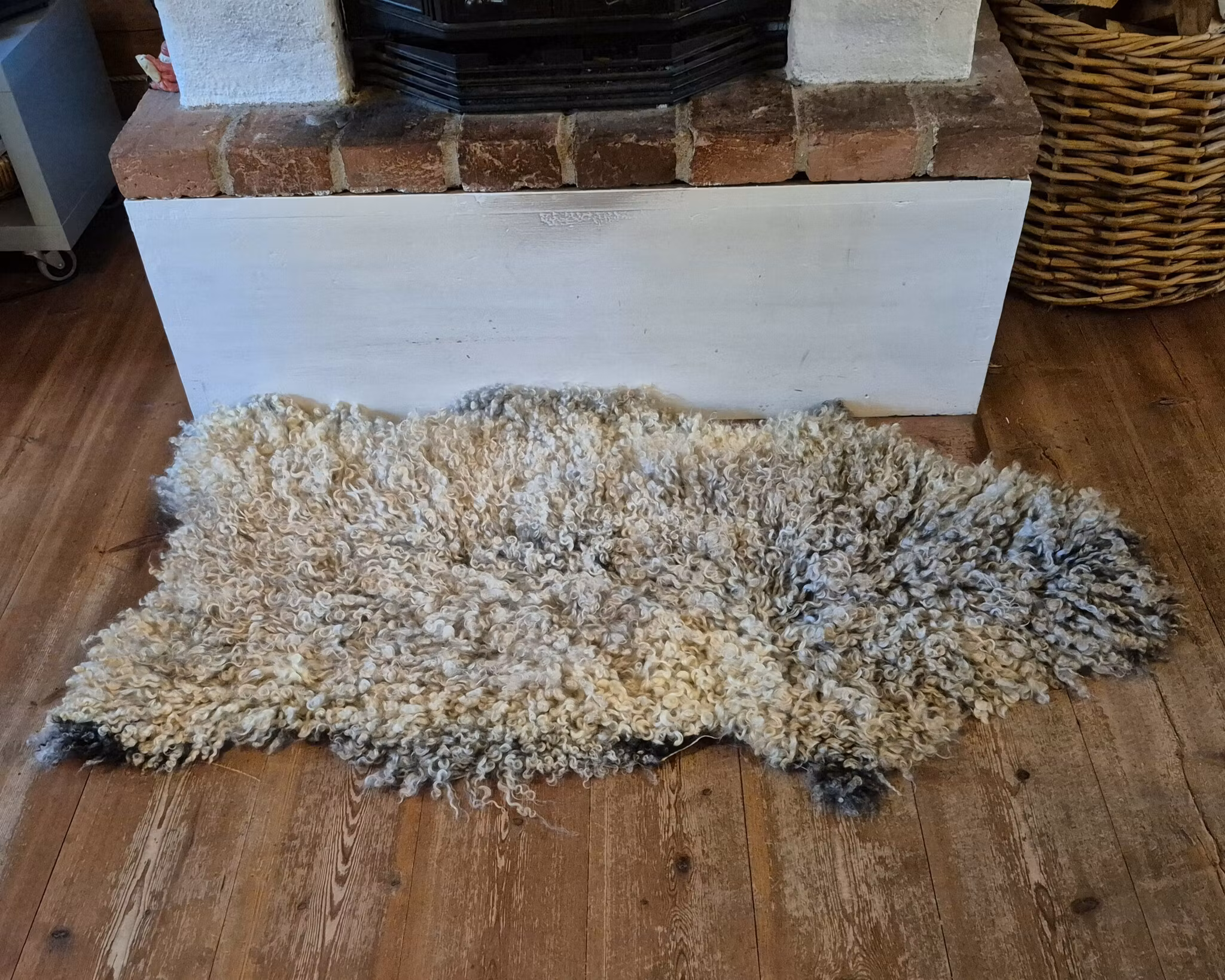 Fårfäll med mörk botten och grå/vita lockar