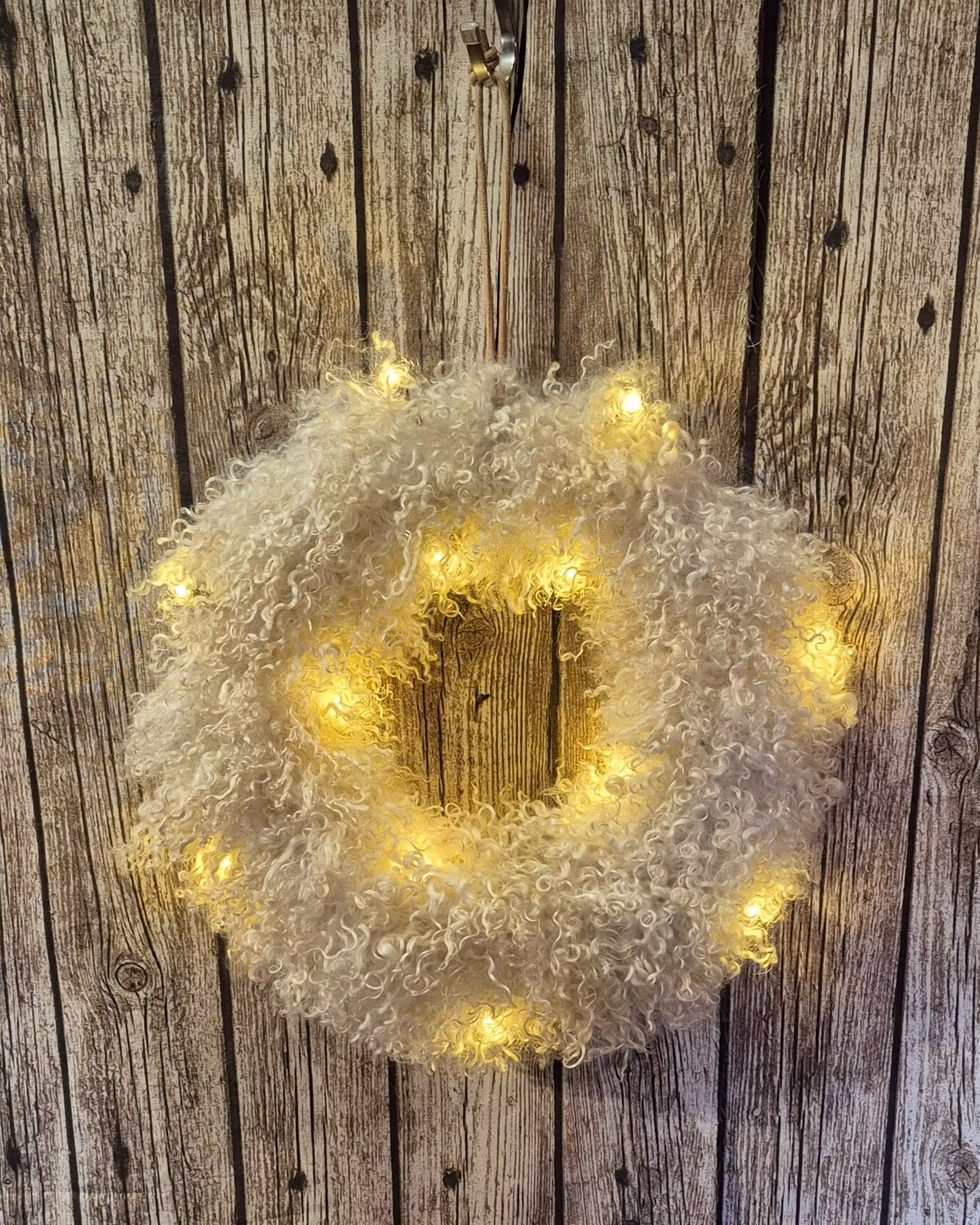 Liten krans med vit/champagneskiftande lockar.