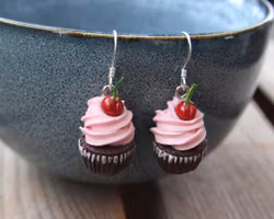 Earrings, chocolate cupcakes with pink frosting and cherries.