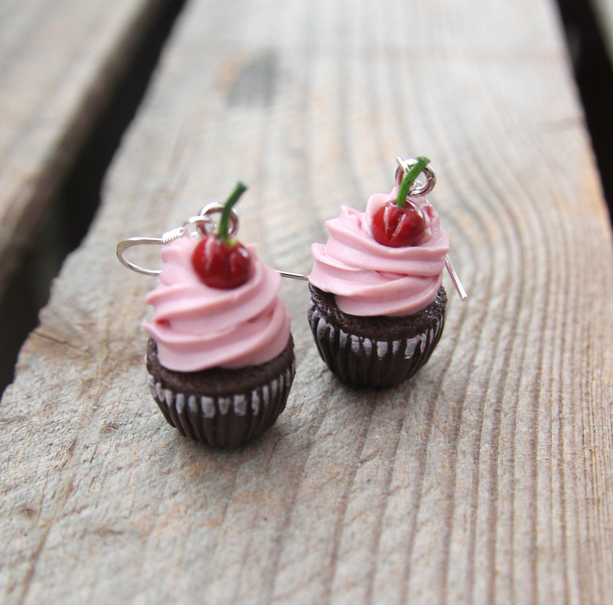 Örhängen, chokladcupcakes med rosa frosting och körsbär.