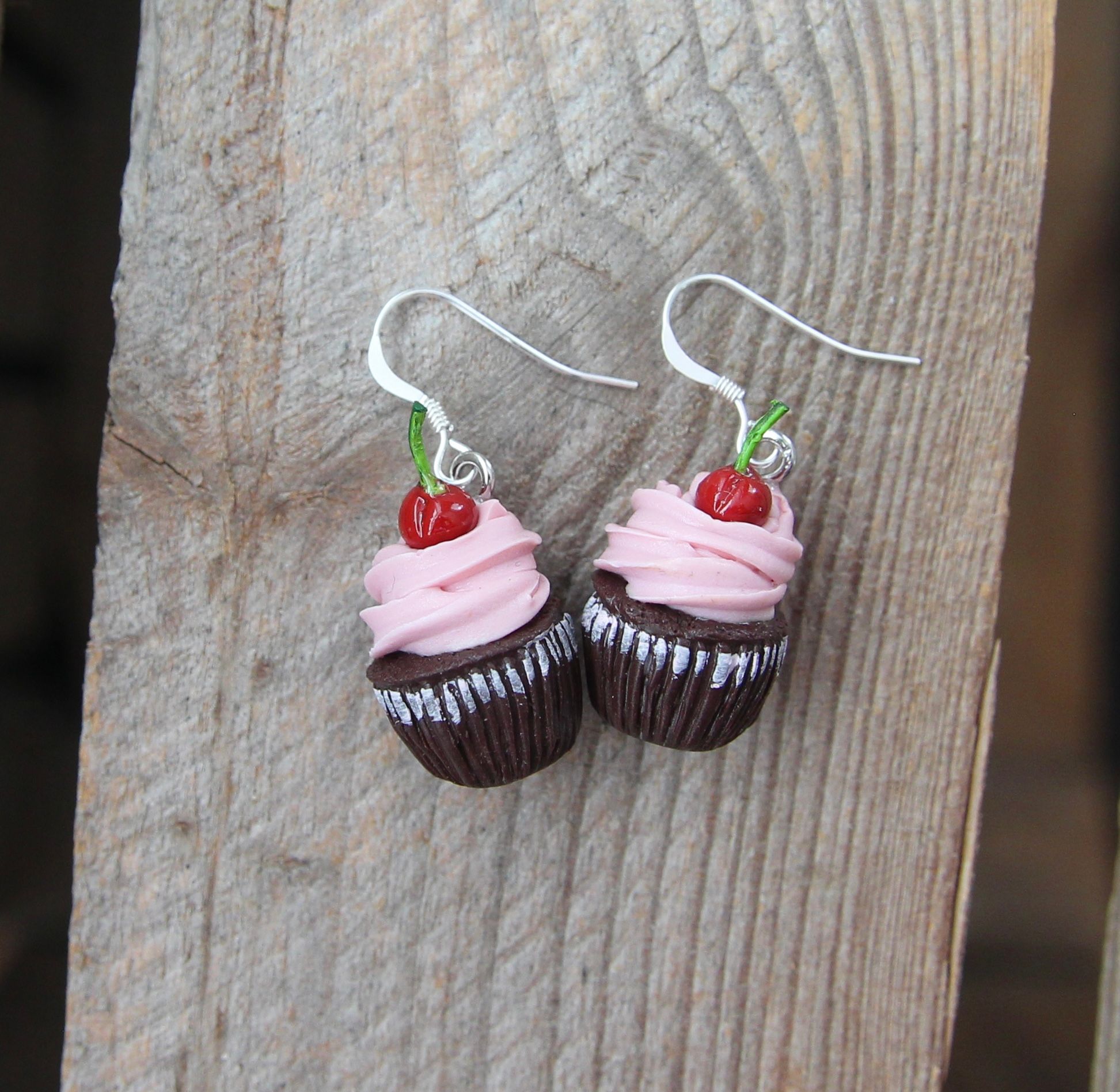 Örhängen, chokladcupcakes med rosa frosting och körsbär.