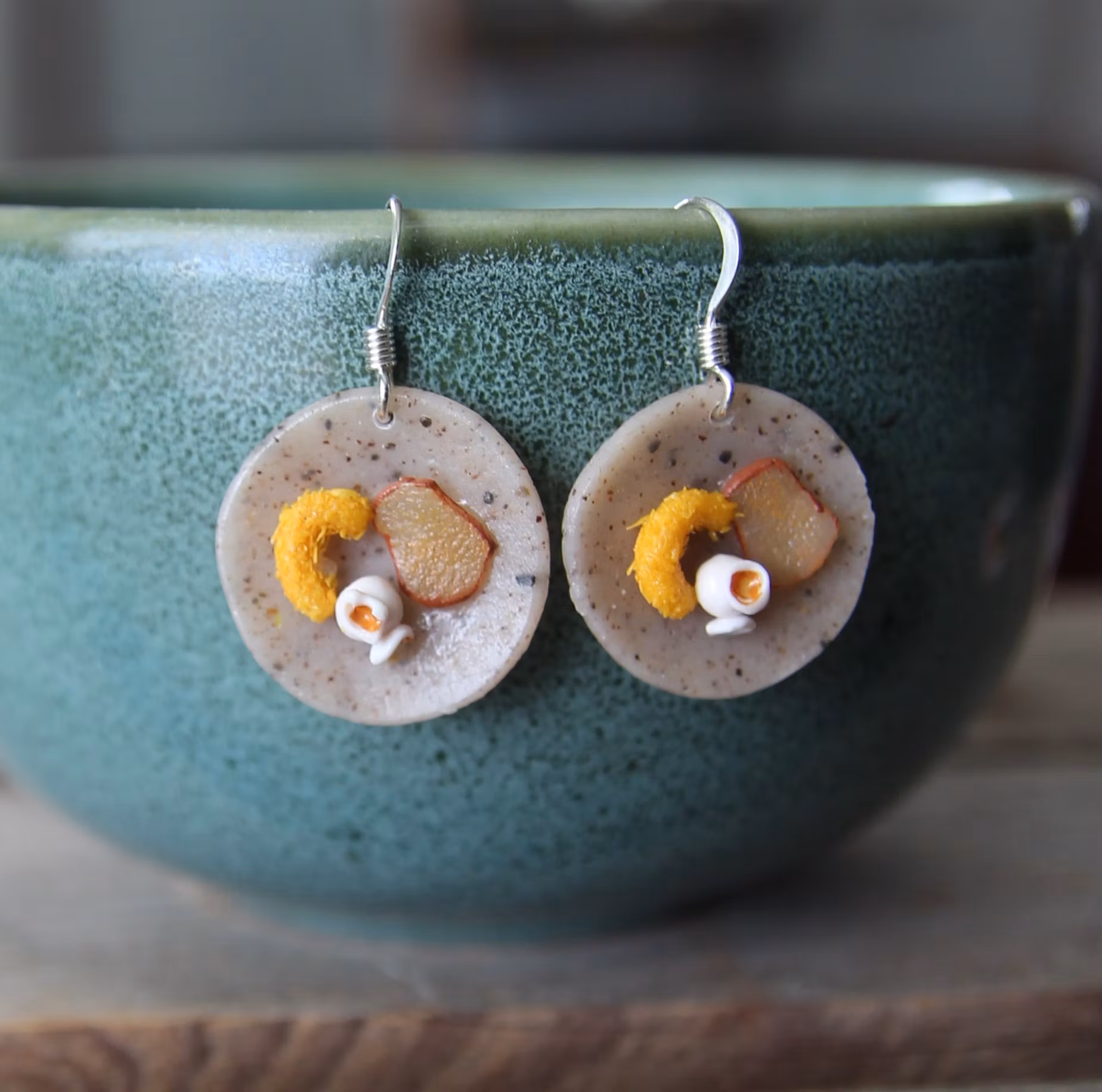 Earrings, blue coffee plates with vacuum cleaner, chocolate ball and cinnamon bun