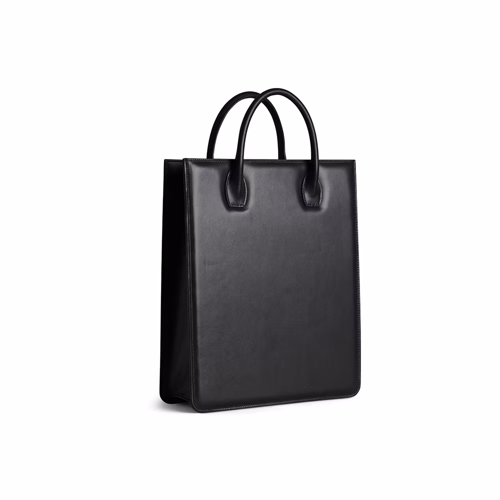 Svart tote bag No 1 stående med laptop och tidning i